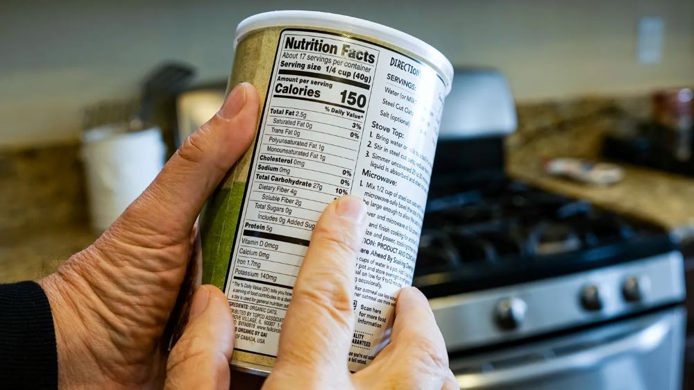 Hands holding a can, pointing to Nutrition Facts label