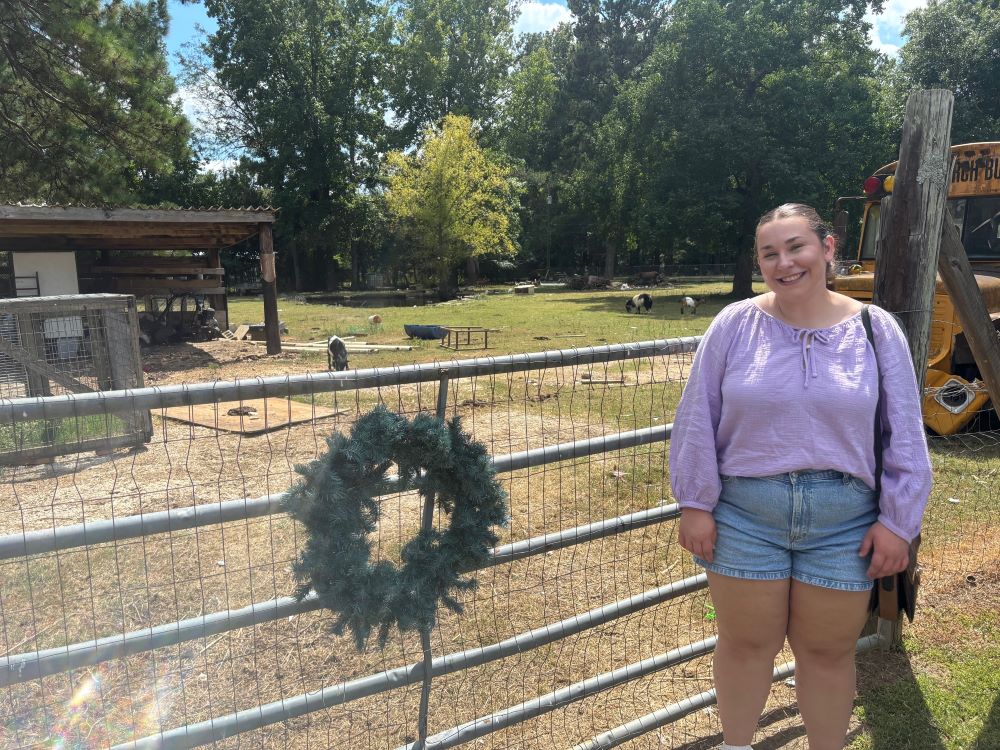 Madison Melton posing for photo at a small goat farm in Butler