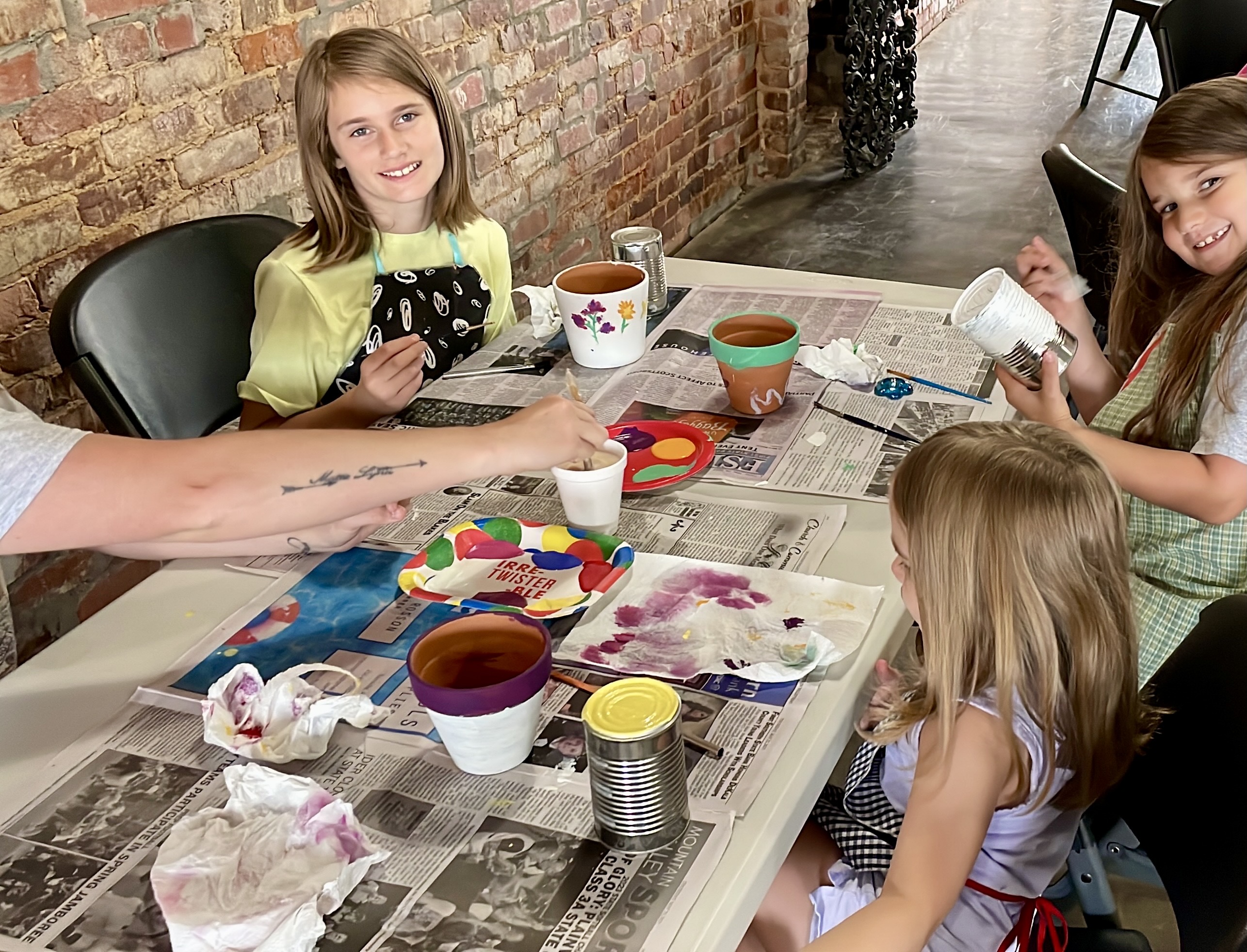 children paint small terracotta planters